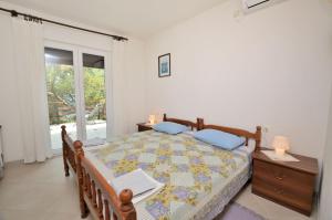 a bedroom with a bed with a table and a window at Apartment Anica in Štivan
