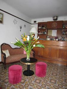 una stanza con un tavolo con un vaso di fiori e due sgabelli di Hotel Belle Vue a Le Lavandou Altre 24 foto