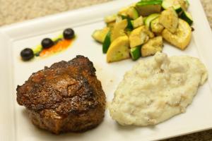 un plato de comida con carne, patatas y hortalizas en Hotel Indigo Waco, an IHG Hotel en Waco