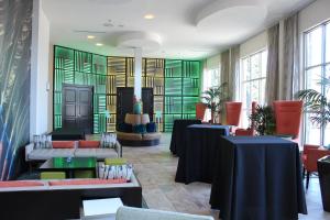 Habitación con mesas, sillas y ventanas. en Hotel Indigo Waco, an IHG Hotel en Waco