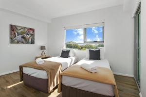 a bedroom with a bed and a painting on the wall at Proximity Waterfront Apartments in Redcliffe