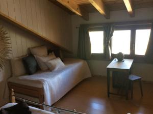 SavièseにあるChez Philippeのベッドルーム1室(ベッド1台、テーブル、窓付)