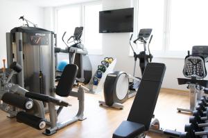 a gym with several treadmills and exercise machines at EDELMANNs Hotel in Kematen in Tirol