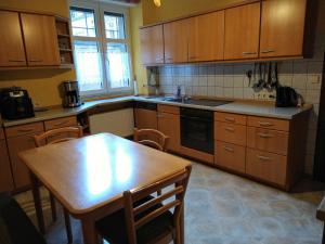 une cuisine avec des placards en bois, une table en bois, une table et des chaises dans l'établissement Ferienhaus Casa Alfredo, à Pommern