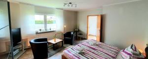 a bedroom with a bed and a table and a window at Strandläufer Darßer Weg in Zingst