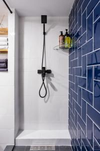 um chuveiro na casa de banho com uma parede de azulejos azuis em Two level apartment for 5 em Chornomorsk