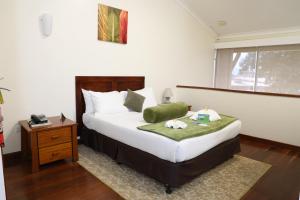 a bedroom with a bed with a nightstand and a bed sidx sidx at Huon Gulf Hotel in Lae