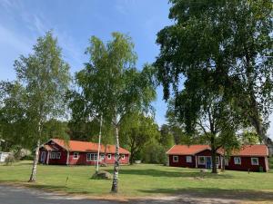 two red houses in a field with trees at 4hearts b&b in Sölvesborg