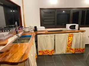 a kitchen with a wooden counter top with a sink at Moorea Chill House And Beach in Teavaro