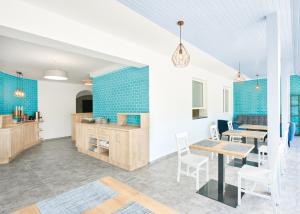 a kitchen and dining room with blue tiles at Lorelei Pension Adults Only in Gyenesdiás