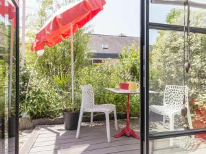 南特的住宿－Gîte Nantes, 1 pièce, 2 personnes - FR-1-306-1182，庭院配有两把椅子、一张桌子和一把遮阳伞