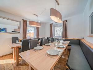 un comedor con una larga mesa de madera y sillas en Chalet Kirchberg L, en Kirchberg in Tirol