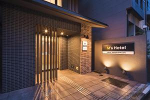 a hotel entrance with a sign on the side of a building at M's Hotel Gojo Naginatagiri in Kyoto