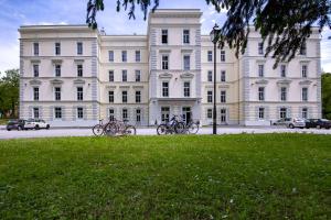 a large white building with bikes parked in front of it at Hostel Bedem in Karlovac