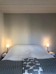 ein Schlafzimmer mit einem großen weißen Bett mit zwei Lampen in der Unterkunft Garden Street Family in Turku