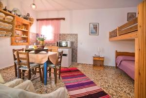 a kitchen and dining room with a table and a bunk bed at Petroula Apartments in Emborios