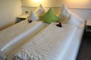 Una cama con almohadas blancas y verdes. en Appartementhaus im Himmelreich, en Lam