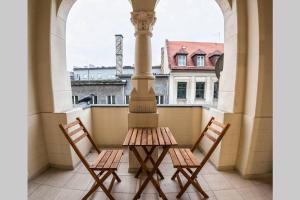 2 Stühle und ein Tisch auf dem Balkon in der Unterkunft Niebieski apartament Teatralna in Kattowitz + 4 Fotos