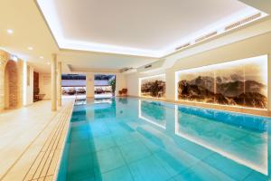 a swimming pool in a house with blue water at Hotel Garni Schellenberg in Oberstdorf