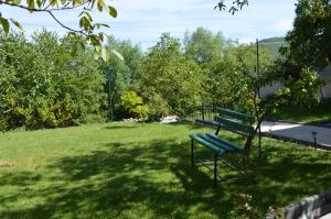 a green park bench sitting in the grass at Macedonia, Accommodations,rentals"Villa Vevcani" Vevchani in Vevčani