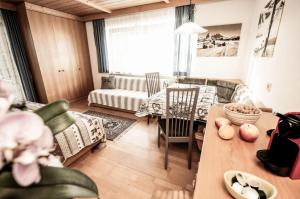 - un salon avec un canapé et une table dans l'établissement Bergfrieden Apartment 2 B, à Alpe di Siusi