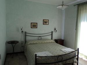ein Schlafzimmer mit einem Bett, einer Lampe und einem Fenster in der Unterkunft Agriturismo Poggio Torreano in Farnese