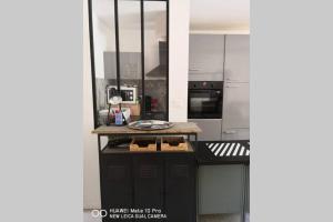 - une cuisine avec un comptoir et une plaque de cuisson dans l'établissement Appartement avec Jardin privatif centre ville, à Hyères