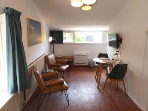 a living room with chairs and a table and a window at Bed and Breakfast Oosterpark in Harlingen