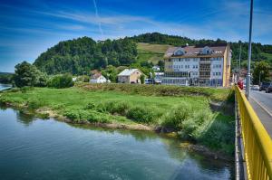 un edificio en una colina junto a un río en Motel New Sanatron, en Bosanski Novi