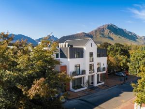 an aerial view of a white building with a mountain in the background at Hotel Krige in Stellenbosch