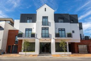 een wit gebouw met een zwart dak bij Hotel Krige in Stellenbosch