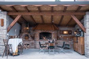 a patio with a brick fireplace and a table and chairs at Kuca Magnolija in Nuštar