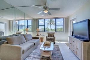 a living room with a couch and a flat screen tv at Harbor Towers 1 Bedroom Pool View in Siesta Key