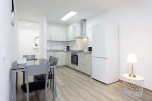 eine Küche mit einem Tisch und einem weißen Kühlschrank in der Unterkunft Home2Book Charming Apartment Santa Cruz, Wifi in Santa Cruz de Tenerife + 26 Fotos