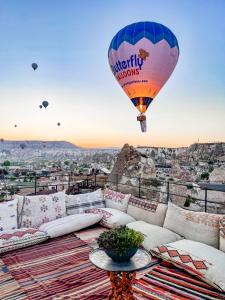 un ballon à air chaud survolant une ville dans l'établissement Luvi Cave Hotel, à Gorëme