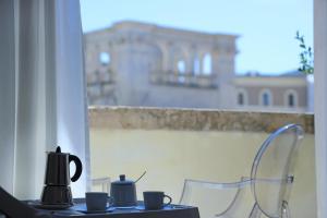 a table with cups on it with a view of a building at Luxury House Lecce -Le mie 3 Suites- in Lecce