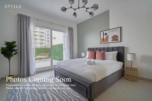 a bedroom with a bed and a large window at Stella Stays Fabulous Studio Dubai JVC Large Terrace in Dubai