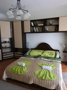 um quarto com uma cama com lençóis e almofadas verdes em Haus Gizella em Harkány