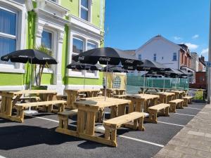 a row of wooden tables and umbrellas on a street at The Beechfield Hotel in Blackpool
