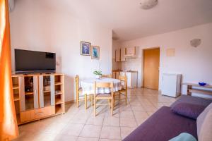 a living room with a table and a tv at Apartments Valentin in Privlaka