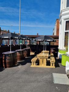 a group of tables and umbrellas on a patio at The Beechfield Hotel in Blackpool