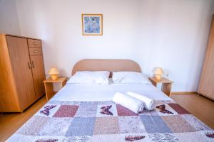 a bedroom with a bed with a quilt on it at Apartments Valentin in Privlaka