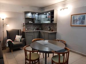 Sirokkó Apartman في بالاتونفوريد: مطبخ وغرفة طعام مع طاولة وكراسي