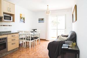 Apartamento con vistas al mar en Pedregalejo playa في مالقة: مطبخ وغرفة معيشة مع أريكة وطاولة