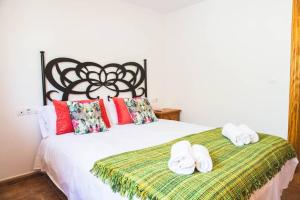 ein Schlafzimmer mit einem weißen Bett und Handtüchern darauf in der Unterkunft Apartamento con vistas al mar en Pedregalejo playa in Málaga