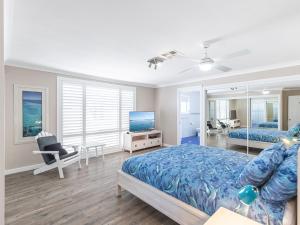 a bedroom with a bed and a television in it at Dolphin Lagoon Luxury Escape in Salamander Bay