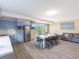 a kitchen and living room with a table and chairs at Dolphin Lagoon Luxury Escape in Salamander Bay