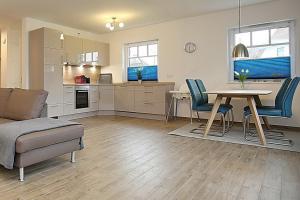 a kitchen and living room with a table and chairs at Reethaus Am Mariannenweg 04a in Boltenhagen