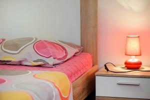 a bedroom with a bed with a lamp on a night stand at Urban City Center in Šibenik
