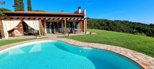 a swimming pool in front of a house at Fonte Murata B&B in Portoferraio